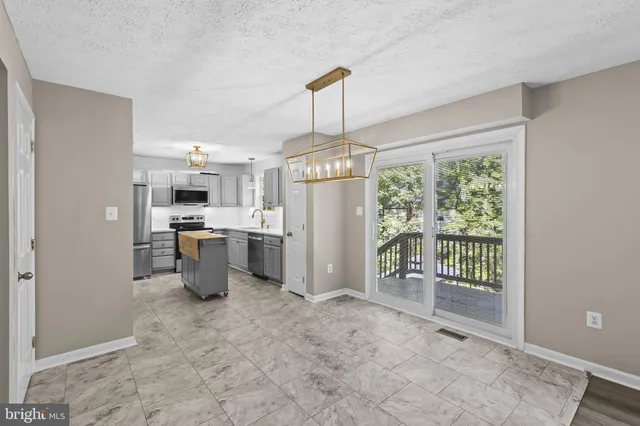a open kitchen with white cabinets and refrigerator