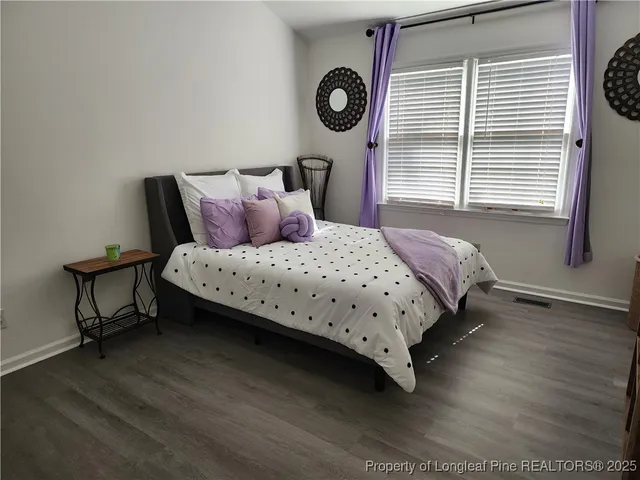 a bedroom with a bed a window and a lamp