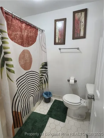 a bathroom with a toilet and a picture on the wall