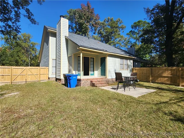 a view of backyard of the house with outdoor seating