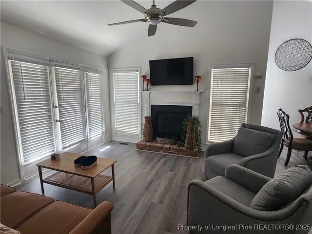 a living room with furniture a flat screen tv and a fireplace