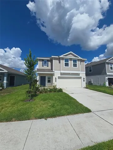 a front view of a house with a yard and garage