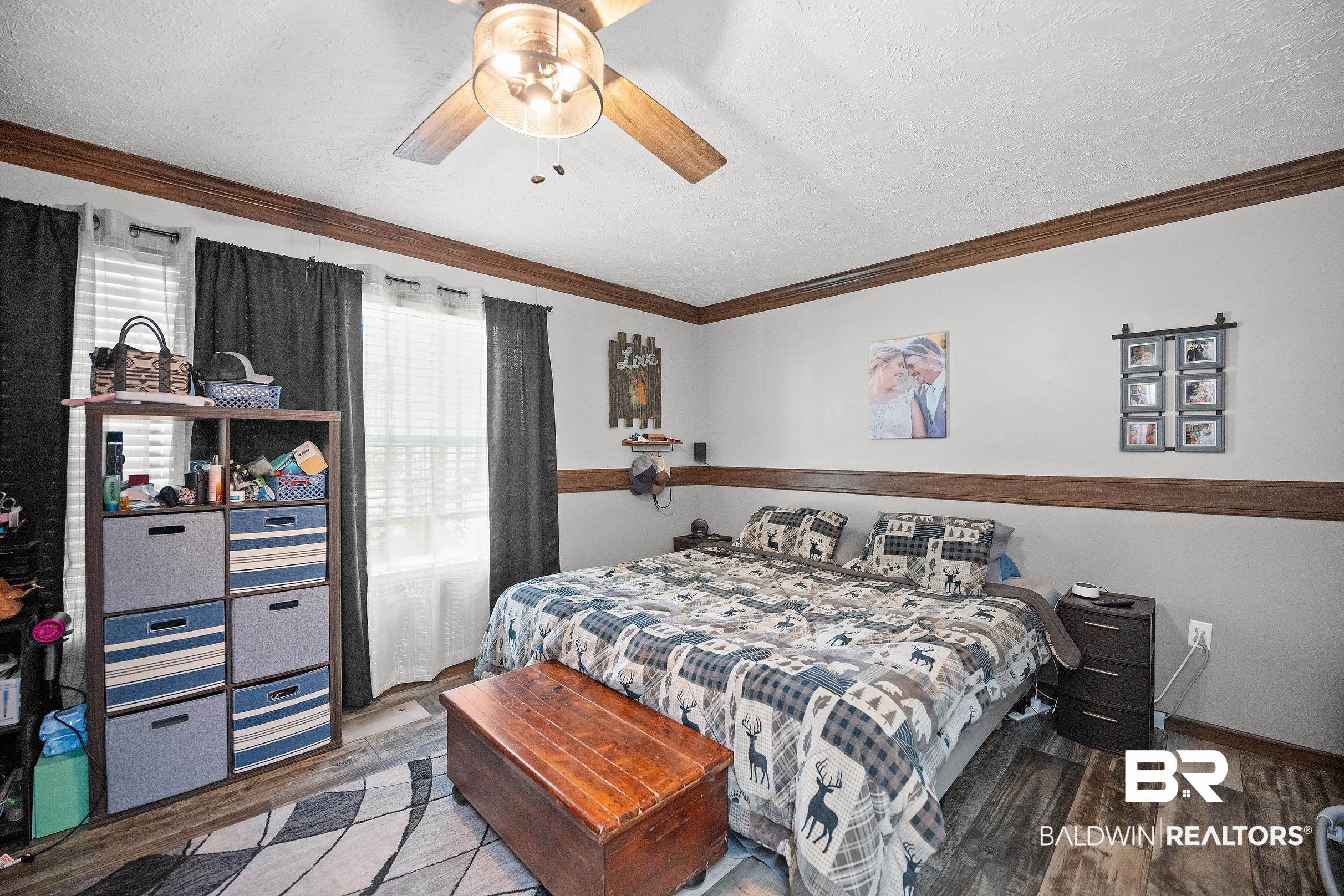 8630 Allison Lane Wilmer, AL 36587 - Photo 19 of 31 Bedroom with a textured ceiling, wood finished floors, ornamental molding, and a ceiling fan