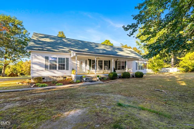 a view of a house with a big yard and large tree