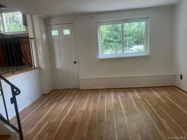 a view of a room with wooden floor and a window