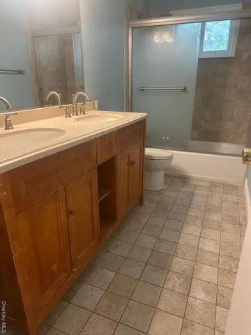 a spacious bathroom with a sink a toilet and mirror