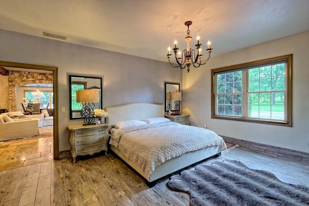 1422 Wolffork Road Rabun Gap, GA 30568 - Photo 17 of 78 a bedroom with a bed and a chandelier