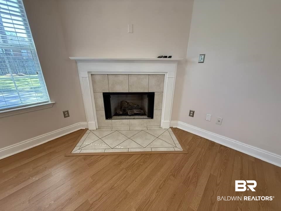 10428 South Side Loop Fairhope, AL 36532 - Photo 11 of 28 Interior details with baseboards, a tiled fireplace, and wood finished floors