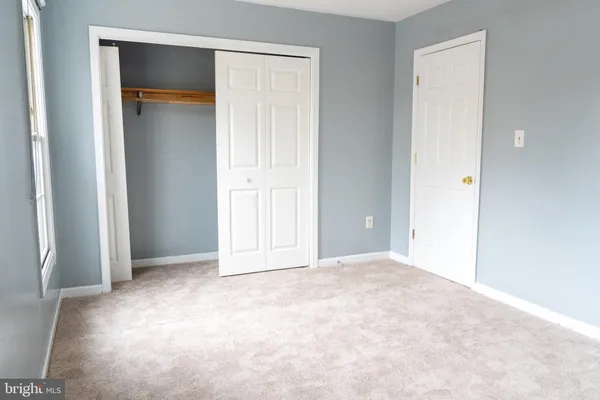 an empty room with closet and a bathroom