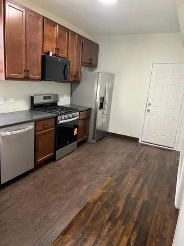 a kitchen with stainless steel appliances granite countertop a stove a sink and a refrigerator