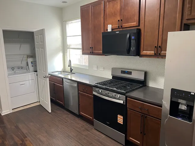 a kitchen with stainless steel appliances a stove a microwave a sink and cabinets