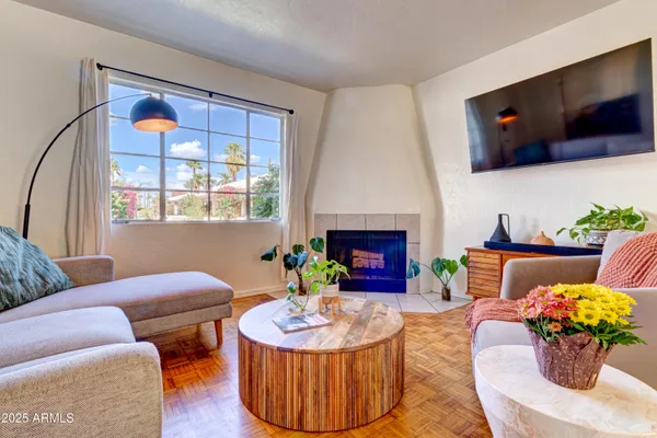 a living room with furniture a fireplace and a flat screen tv