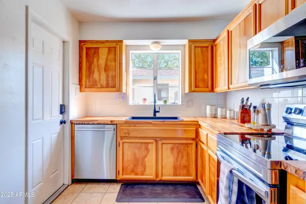 a kitchen with stainless steel appliances granite countertop a sink and a wooden cabinets