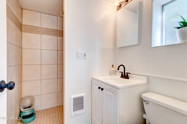 a bathroom with a sink a toilet and shower