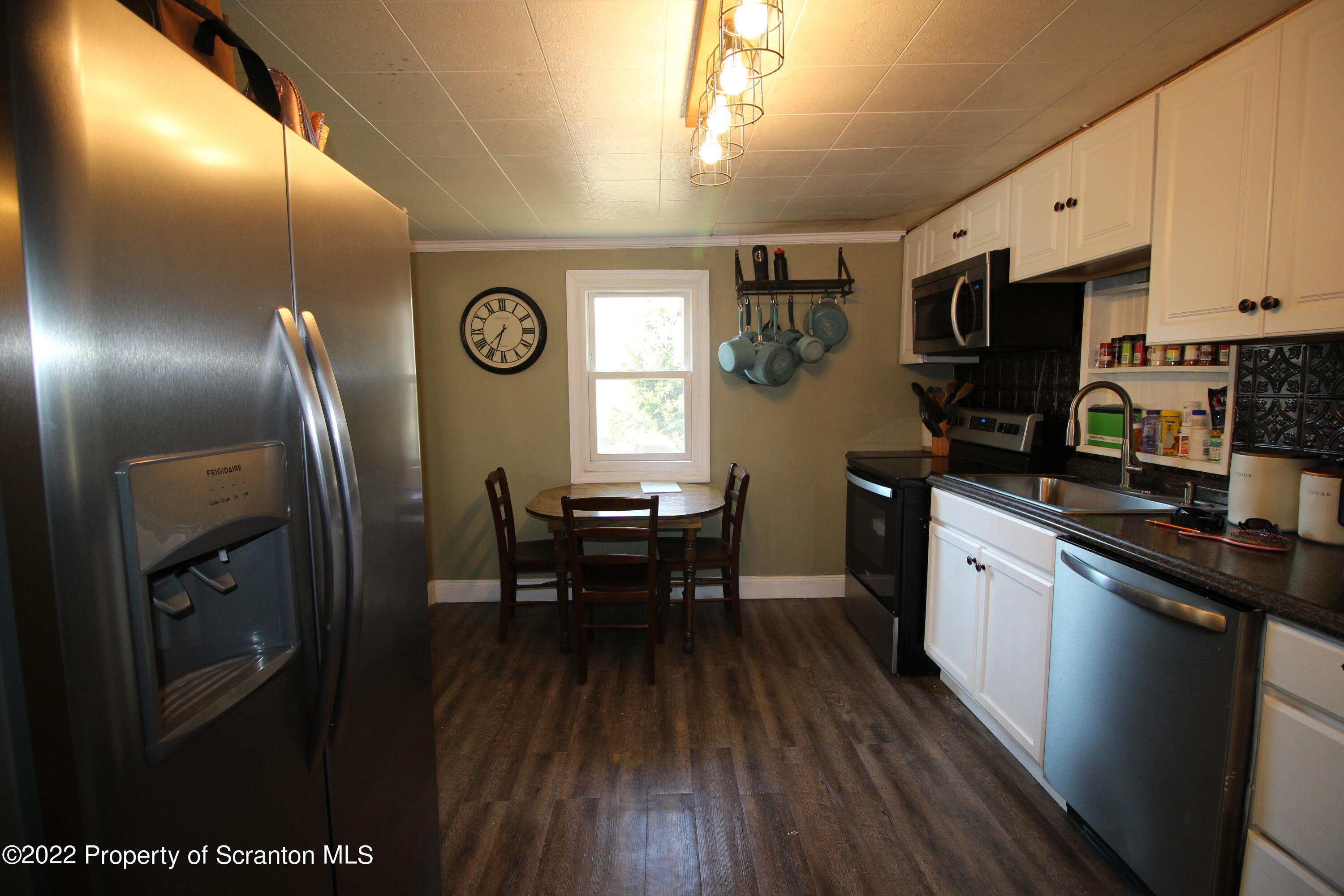 4001 Quicktown Road Moscow, PA 18444 - Photo 5 of 24 a kitchen with stainless steel appliances granite countertop a refrigerator a stove a sink a dining table and chairs with wooden floor