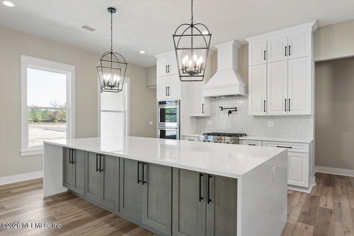 34883 Steeple Chase Way Callahan, FL 32011 - Photo 16 of 88 a kitchen with kitchen island granite countertop a sink a counter space and a window