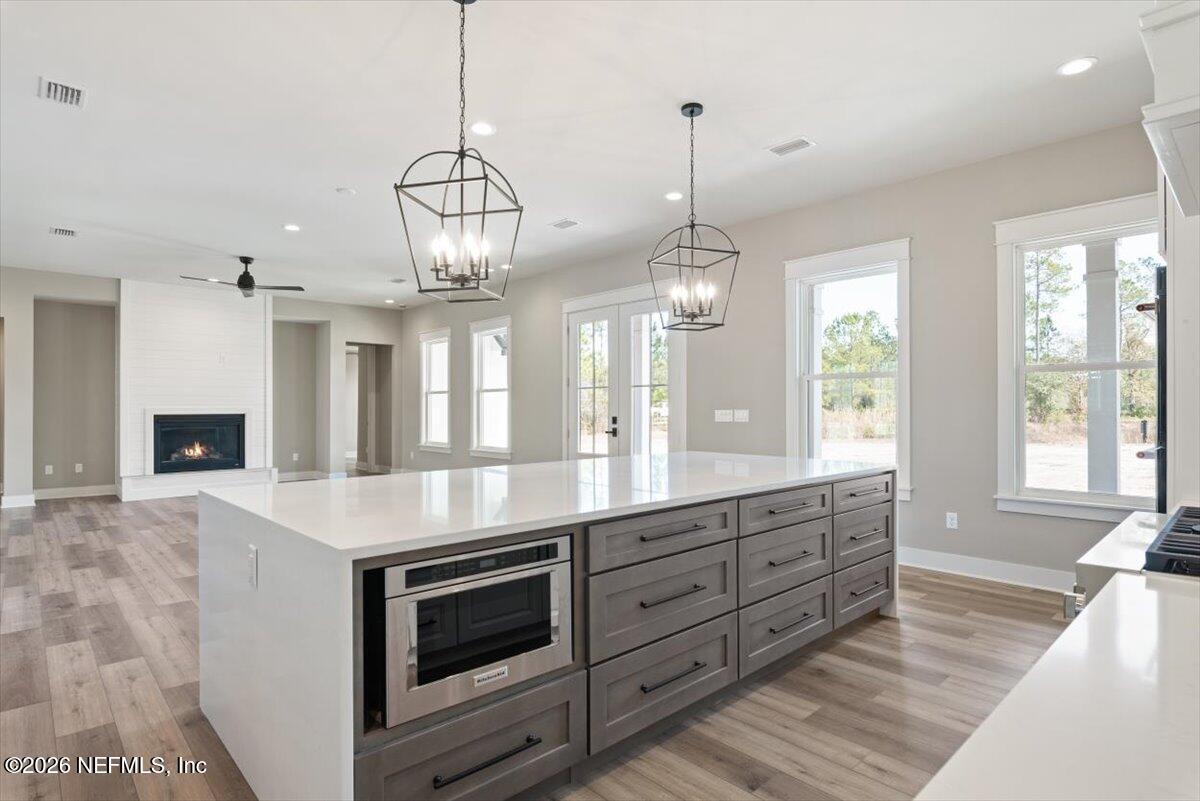 34883 Steeple Chase Way Callahan, FL 32011 - Photo 17 of 88 a open kitchen with stainless steel appliances granite countertop a stove and cabinets with wooden floor