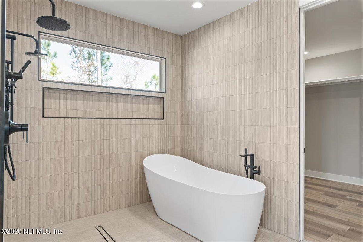 34883 Steeple Chase Way Callahan, FL 32011 - Photo 25 of 88 a bathroom with a white bath tub a window and a shower