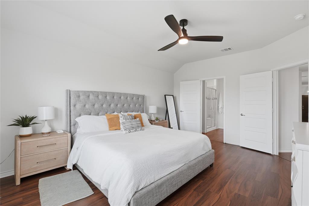 10101 Travis Road Little Elm, TX 75068 - Photo 20 of 26 a bedroom with a bed and a ceiling fan