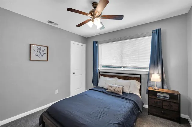 a bedroom with a bed and a ceiling fan