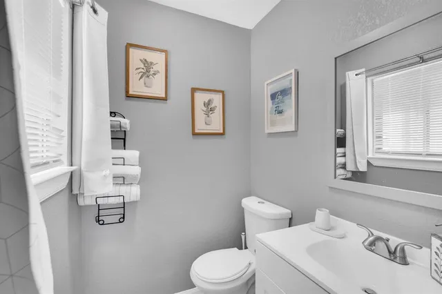 a bathroom with a sink vanity mirror and toilet
