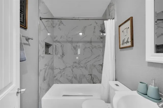 a bathroom with a toilet and a shower curtain