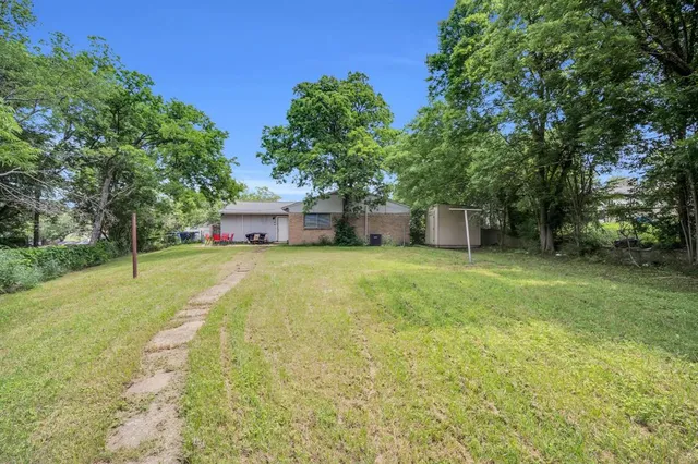 a yellow house with trees in front of it