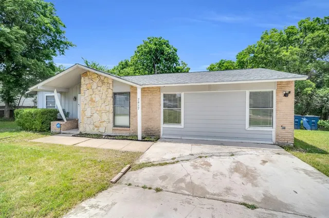 a front view of a house with a garden and yard