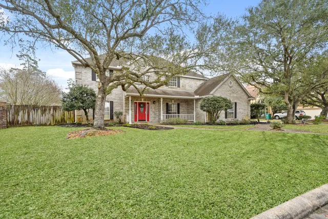a view of a yard with large trees and a barn