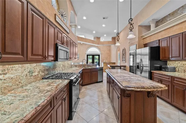 a kitchen with granite countertop a sink stove and cabinets