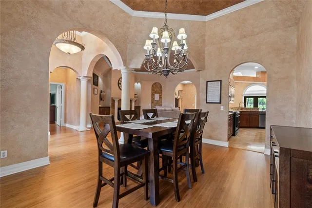 a view of a dining room with furniture a chandelier and wooden floor