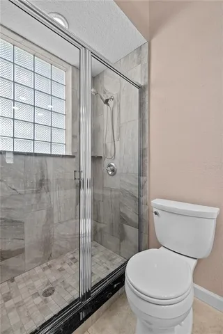 a bathroom with a toilet and a shower