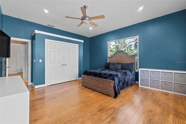 a bedroom with a large bed chandelier and a window