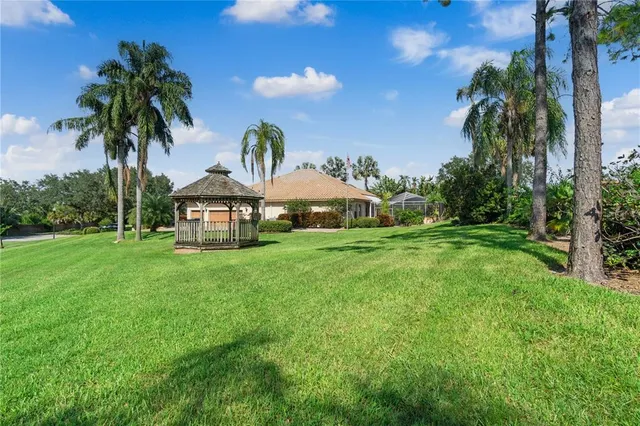 a view of a house with backyard and a tree