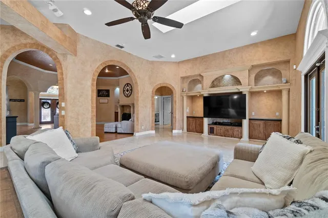 a living room with furniture a large window and a flat screen tv