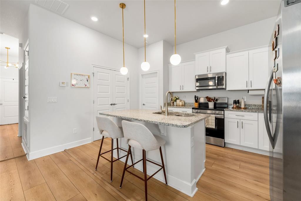 25093 Southwest 23rd Road Newberry, FL 32669 - Photo 10 of 29 a kitchen with kitchen island a white counter top space cabinets and stainless steel appliances