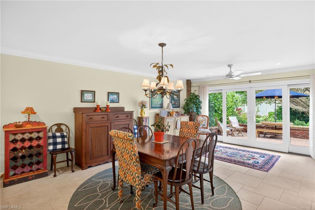 4030 Crayton Road, Unit C2 Naples, FL 34103 - Photo 15 of 32 a dining room with furniture a chandelier and a rug