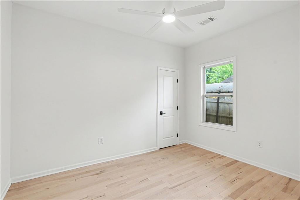 827 Elbert Street Southwest Atlanta, GA 30310 - Photo 14 of 33 an empty room with wooden floor and window