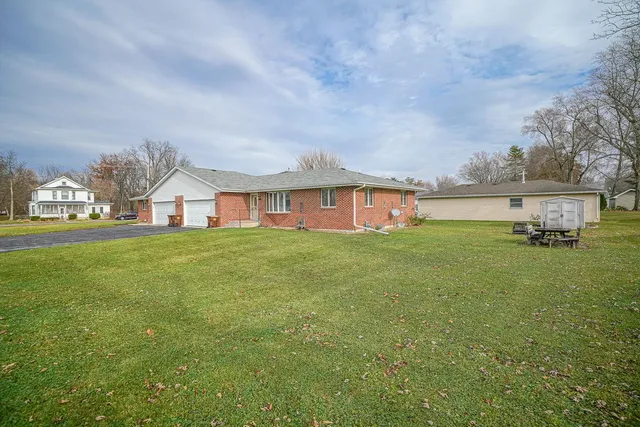 a front view of house with yard and trees in the background