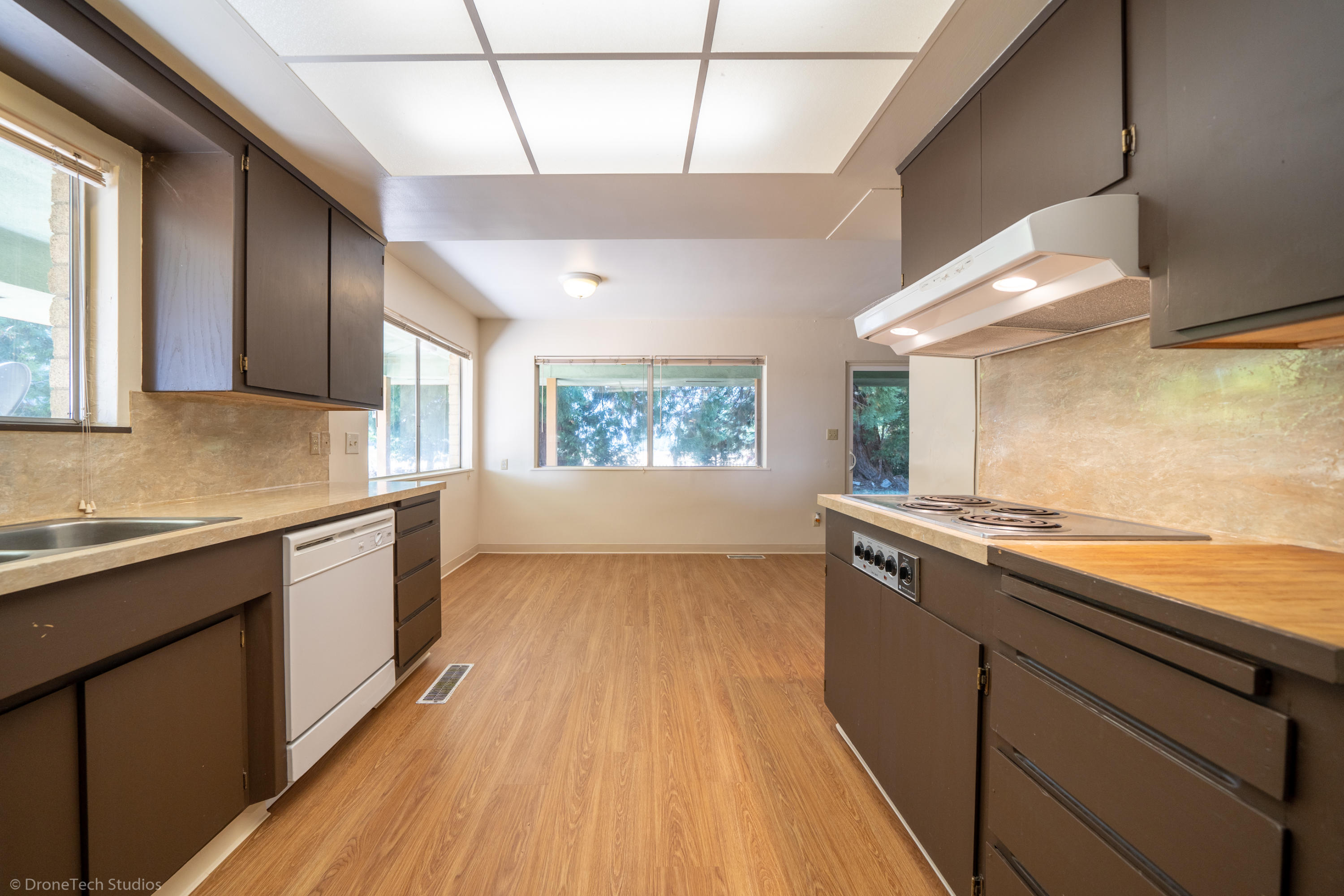 36563 Deer Flat Road Shingletown, CA 96088 - Photo 13 of 65 a kitchen with a wooden floor and white stainless steel appliances