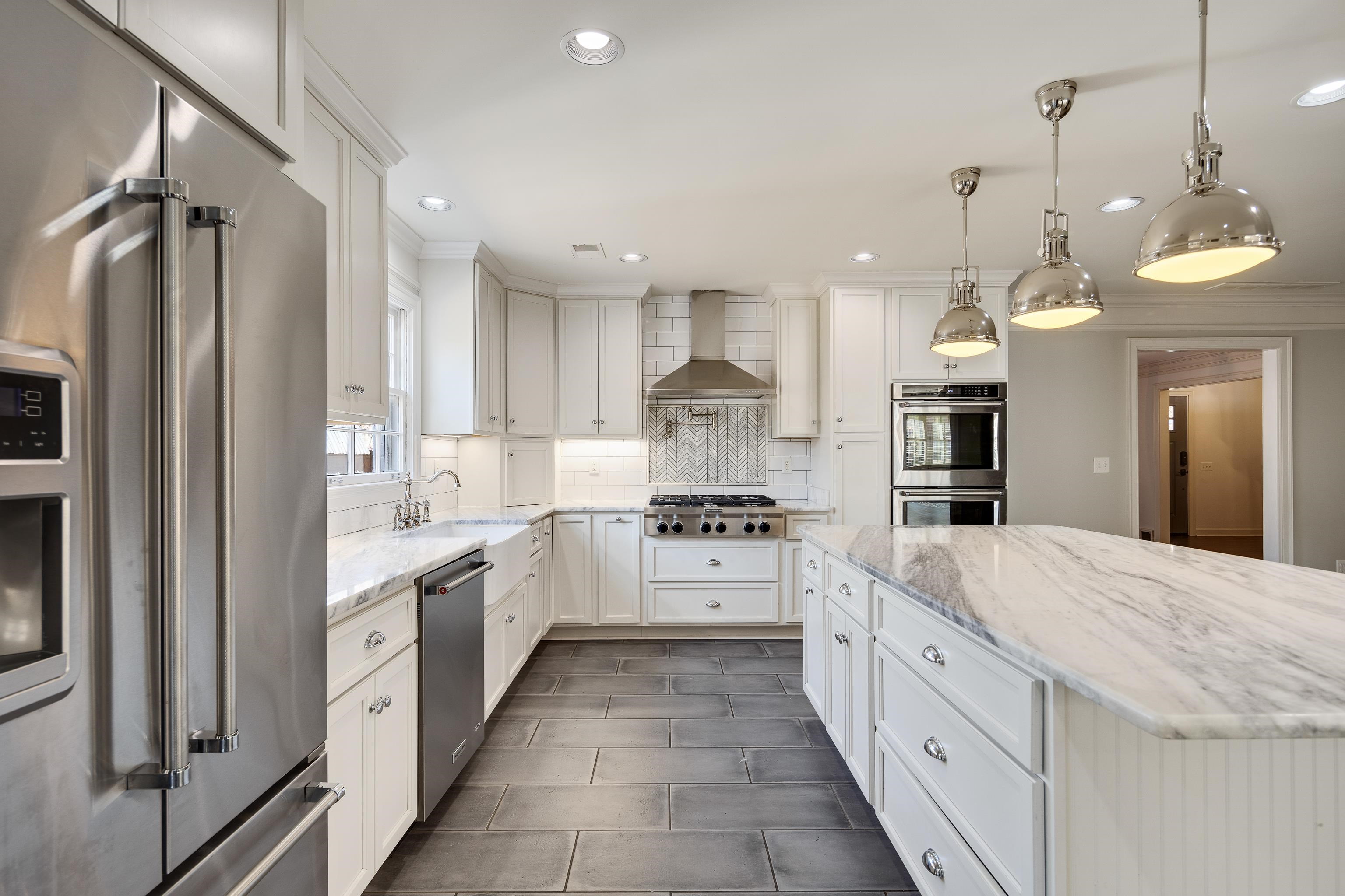 6867 River Birch Road Memphis, TN 38119 - Photo 13 of 40 Kitchen with stainless steel appliances, light stone countertops, white cabinetry, decorative light fixtures, and recessed lighting