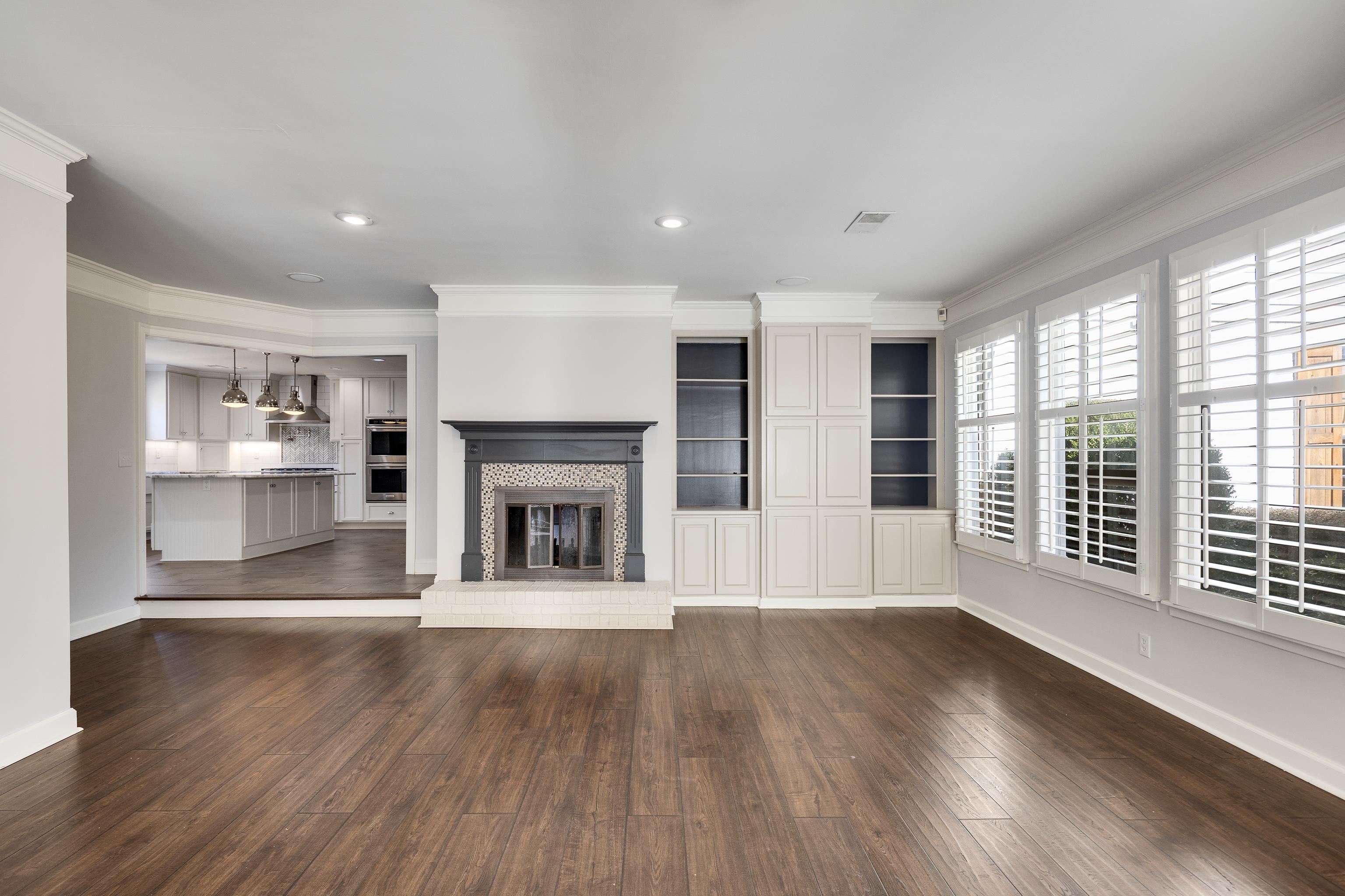 6867 River Birch Road Memphis, TN 38119 - Photo 22 of 40 Unfurnished living room featuring a glass covered fireplace, ornamental molding, dark wood-style flooring, and recessed lighting