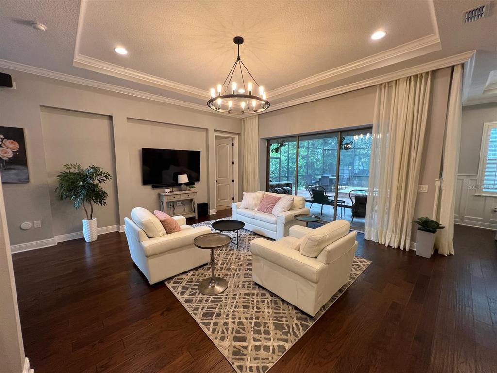 12927 Canopy Woods Way Winter Garden, FL 34787 - Photo 5 of 41 a living room with furniture a fireplace and a chandelier