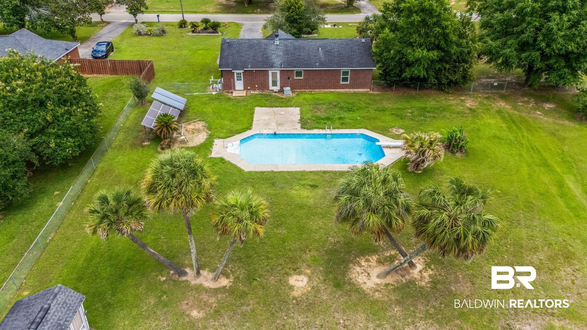 15096 Highland Circle Foley, AL 36535 - Photo 2 of 52 Spacious backyard featuring an in-ground swimming pool with surrounding concrete decking