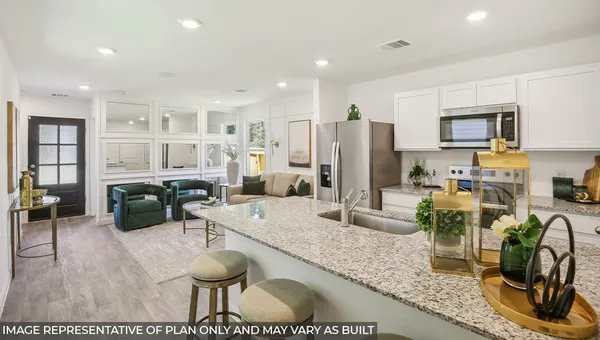 a kitchen with stainless steel appliances granite countertop a refrigerator a stove a sink a dining table and chairs with wooden floor
