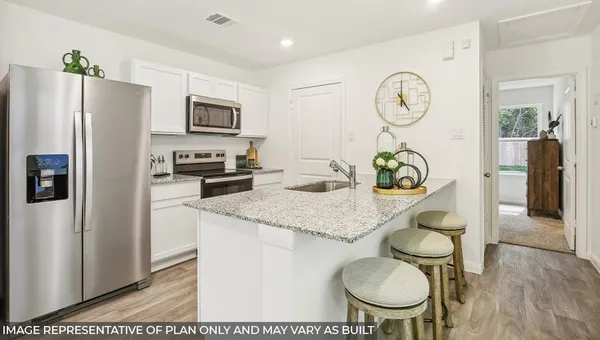 a kitchen with stainless steel appliances granite countertop a sink a stove a refrigerator with a dining table and chairs