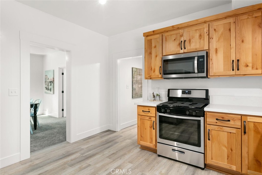 937 Chestnut Street Chico, CA 95928 - Photo 18 of 55 a kitchen with stainless steel appliances a stove a microwave oven cabinets and a wooden floor