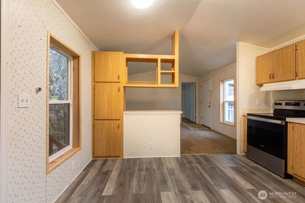 230 Misty Circle Forks, WA 98331 - Photo 14 of 33 a view of a kitchen with wooden floor and a refrigerator