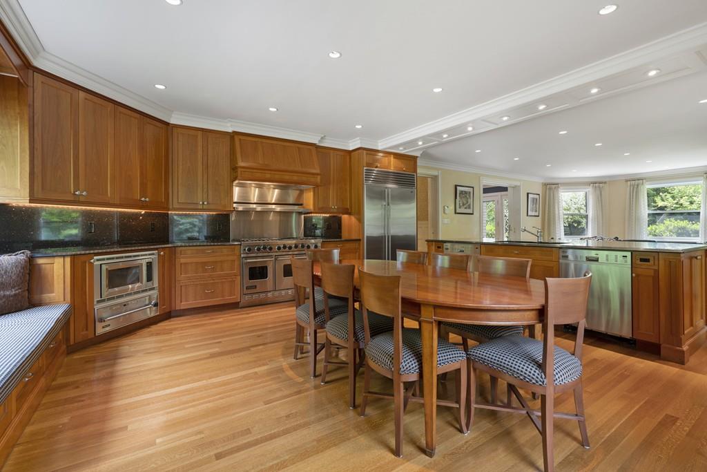 30 Warren Street Brookline, MA 02445 - Photo 21 of 27 a kitchen with stainless steel appliances kitchen island granite countertop a table chairs and a refrigerator