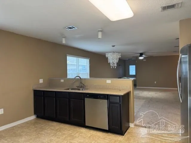 a kitchen with a sink and chandelier